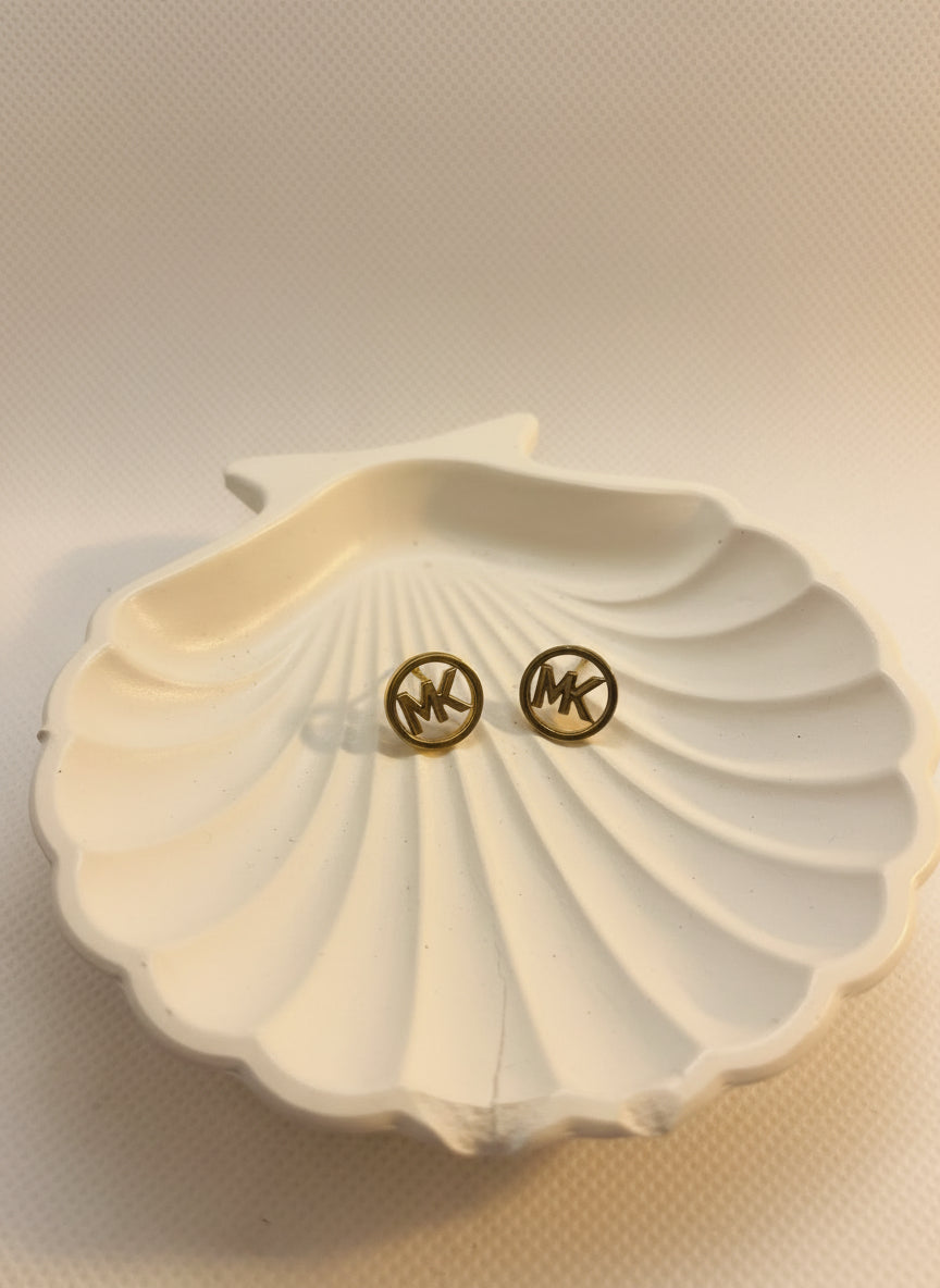 Black Or Dark-toned stud earrings with the letters "MK"